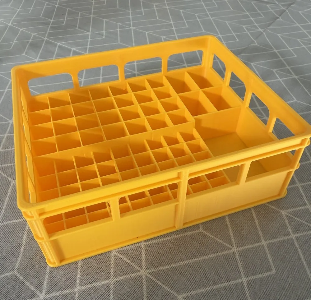 3D-printed Battery Caddy in yellow, top angle showing the empty divider grid